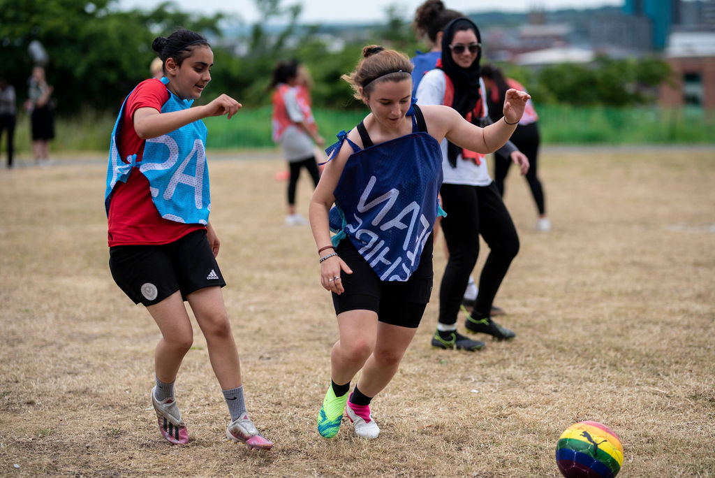 three teams play co-operative football in colourful geometric strips