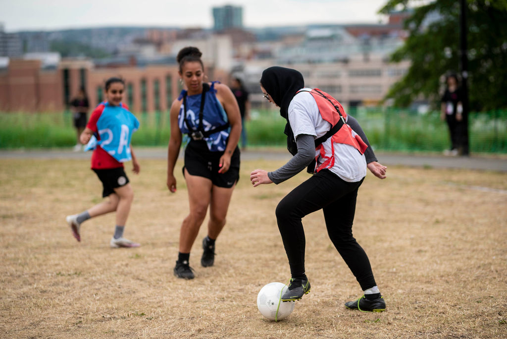 three teams play co-operative football in colourful geometric strips