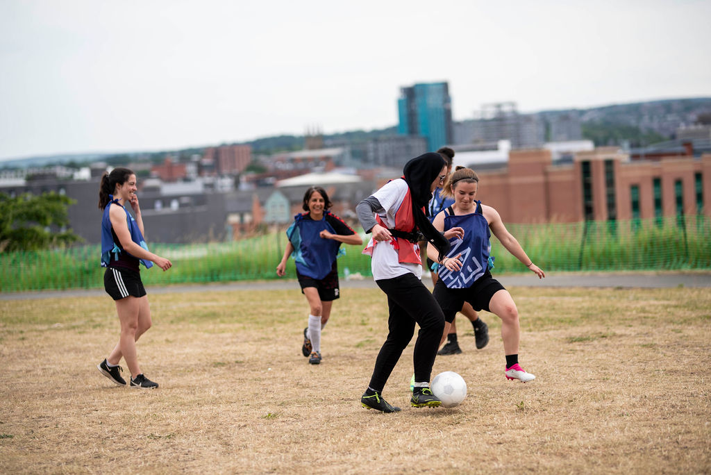 three teams play co-operative football in colourful geometric strips